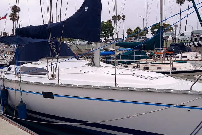 1993 Hunter 40.5 sailboat docked in marina, surrounded by other boats and palm trees.
