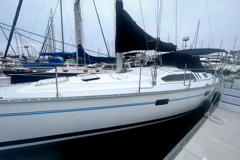 1993 Hunter 40.5 sailboat docked at marina, featuring sleek design and black sail cover.