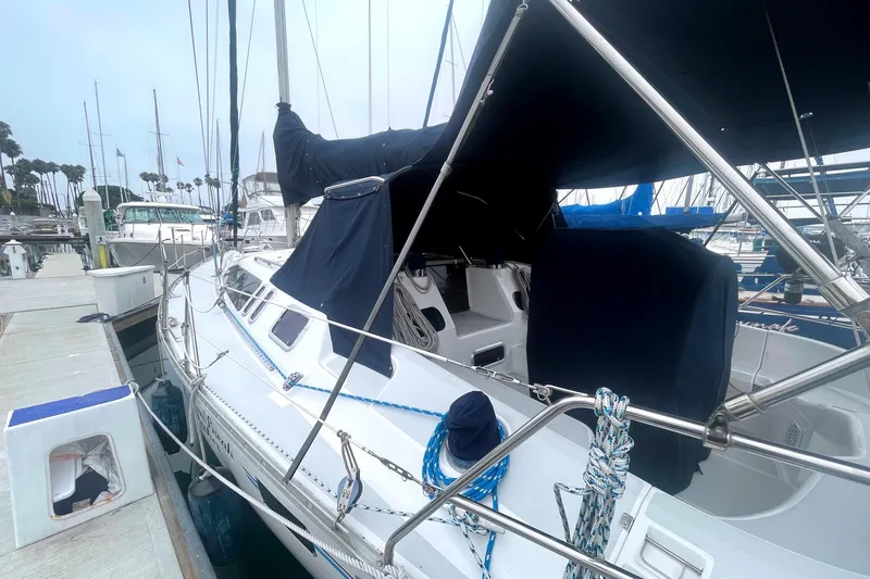Sailboat docked at marina, 1993 Hunter 40.5 model, covered with navy blue canvas.