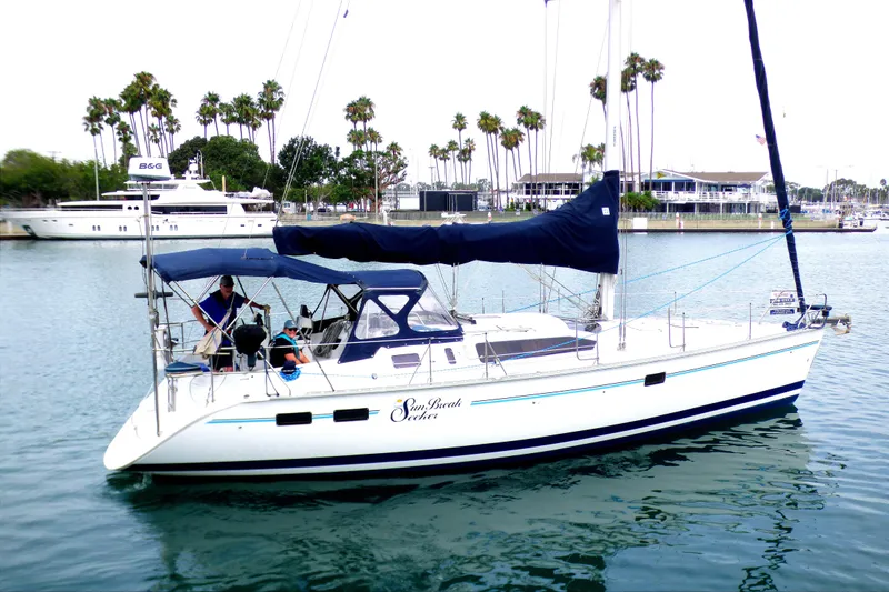 Sailboat Hunter 40.5 (1993) docked in marina with palm trees in background.