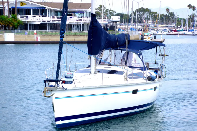 Sailboat Hunter 40.5, 1993 model, docked with "For Sale" sign, marina background.