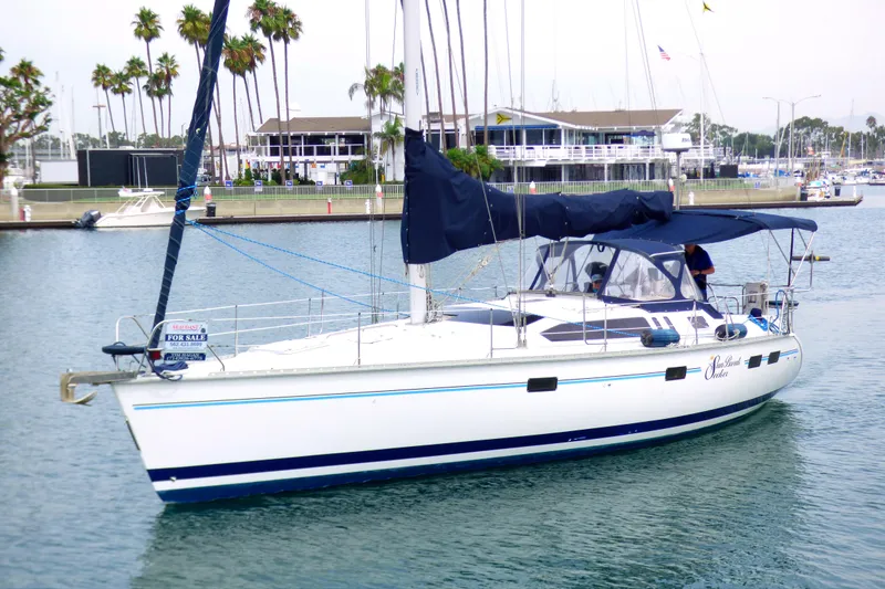 Sailboat Hunter 40.5, 1993 model, docked with "For Sale" sign, marina background.
