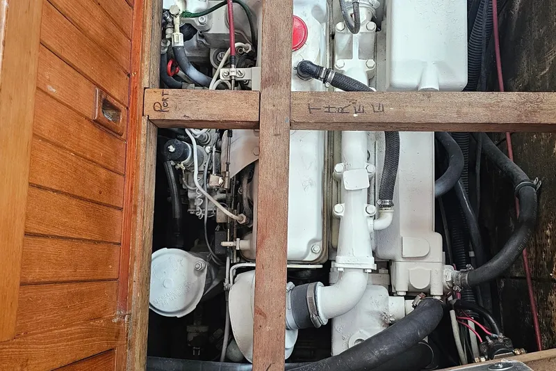 Engine compartment of a 1985 Spindrift Pilot House Cutter, showcasing mechanical components and wooden framing.