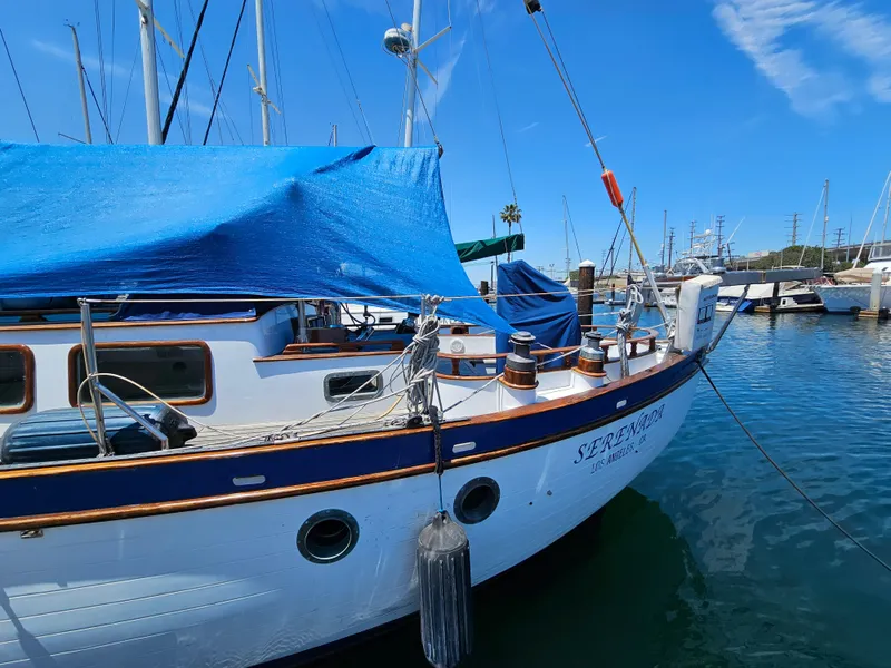 1985 Spindrift Pilot House Cutter docked at marina with blue tarp.