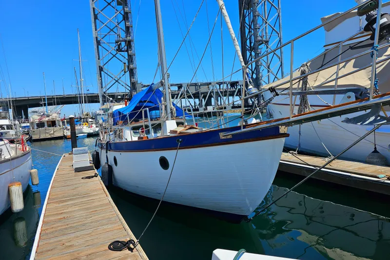 1985 Spindrift Pilot House Cutter docked at marina with blue sky background.
