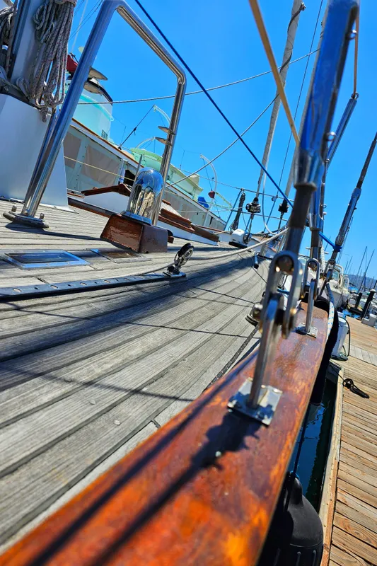 1985 Spindrift Pilot House Cutter deck view with polished wood and metal railings.