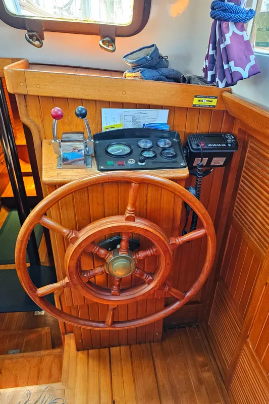 1985 Spindrift Pilot House Cutter wooden helm with navigation controls.