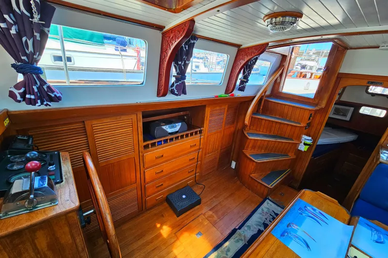 Interior of 1985 Spindrift Pilot House Cutter with wooden cabinetry and stairs.