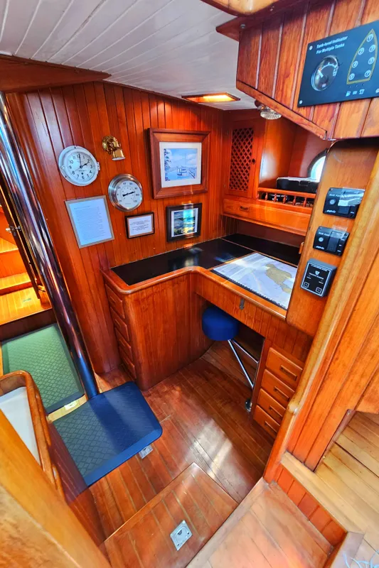 1985 Spindrift Pilot House Cutter navigation station with wooden interior and nautical instruments.