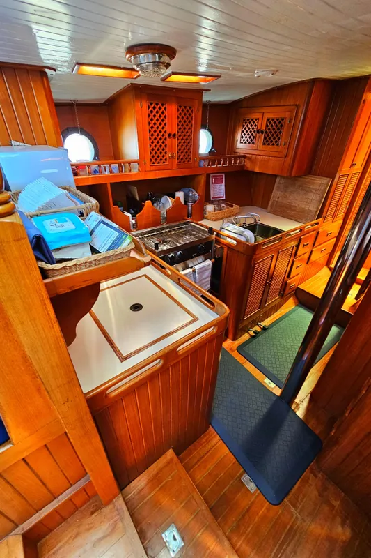 1985 Spindrift Pilot House Cutter interior with wooden cabinetry and kitchen area.