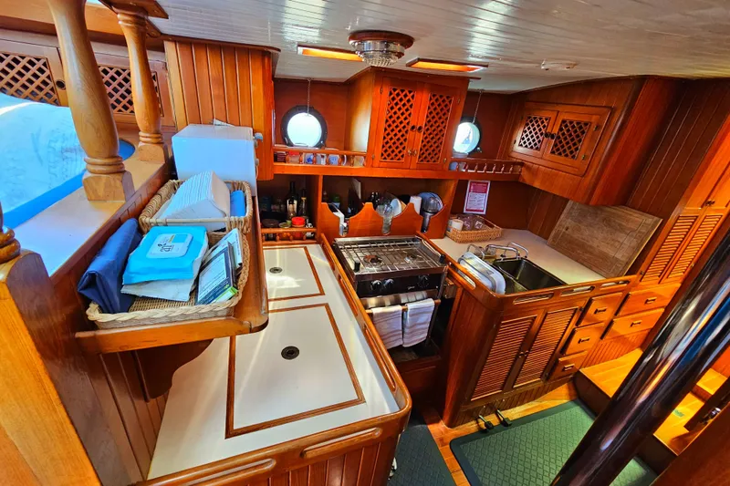 1985 Spindrift Pilot House Cutter kitchen with wooden cabinetry and modern appliances.