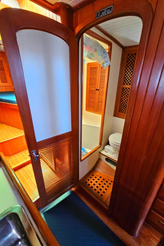 Interior of 1985 Spindrift Pilot House Cutter showing bathroom and wooden cabinetry.