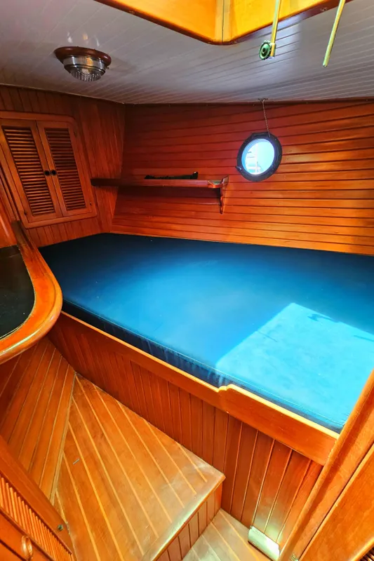 1985 Spindrift Pilot House Cutter cabin with wooden interior and blue mattress.