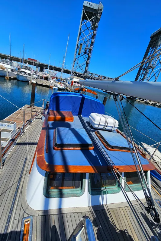 1985 Spindrift Pilot House Cutter docked at a marina with a bridge in the background.
