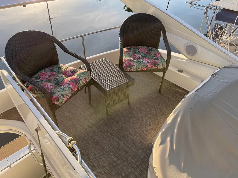 Outdoor seating area on 1997 Maxum 4600 SCB yacht with wicker chairs and floral cushions.