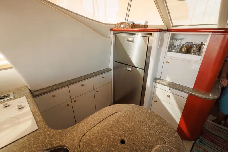 Interior of 1997 Maxum 4600 SCB yacht kitchen with modern appliances and storage cabinets.