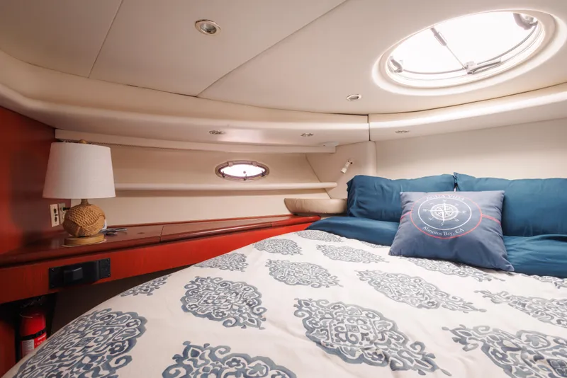 Luxurious cabin interior of 1997 Maxum 4600 SCB yacht with elegant bedding and porthole.