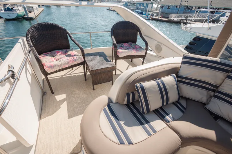 Luxurious seating area on 1997 Maxum 4600 SCB yacht with striped cushions and wicker chairs.