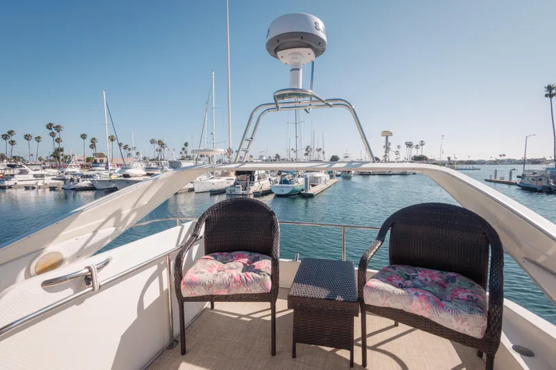 1997 Maxum 4600 SCB yacht deck with chairs, overlooking marina and sailboats.