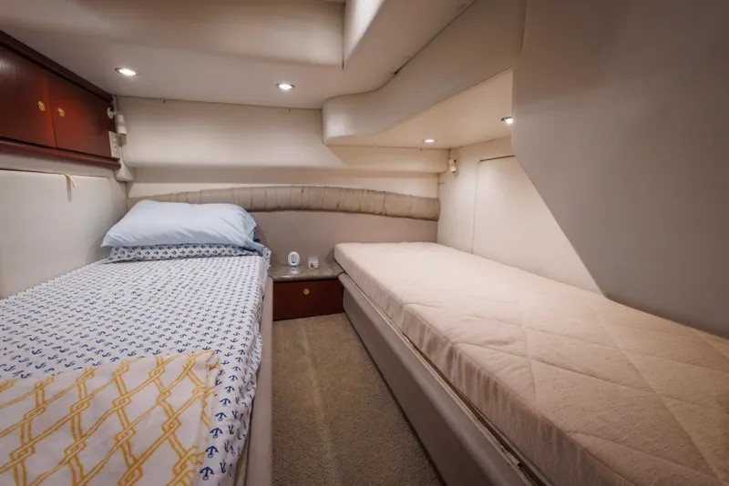 1997 Maxum 4600 SCB yacht cabin with twin beds, cozy lighting, and elegant decor.