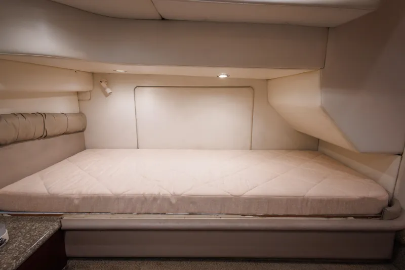Interior cabin of 1997 Maxum 4600 SCB yacht with beige bedding and soft lighting.