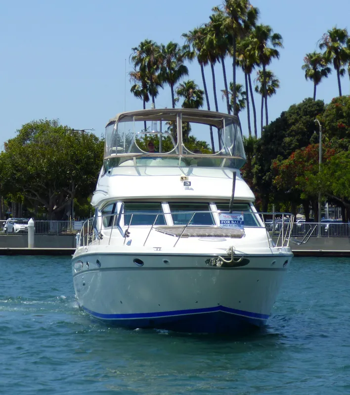 1997 Maxum 4600 SCB yacht on water, palm trees in background, "For Sale" sign visible.