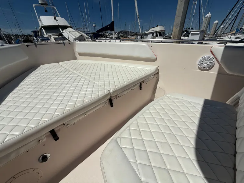2005 Grady-White Bimini 306 boat interior with white cushioned seating in a marina.