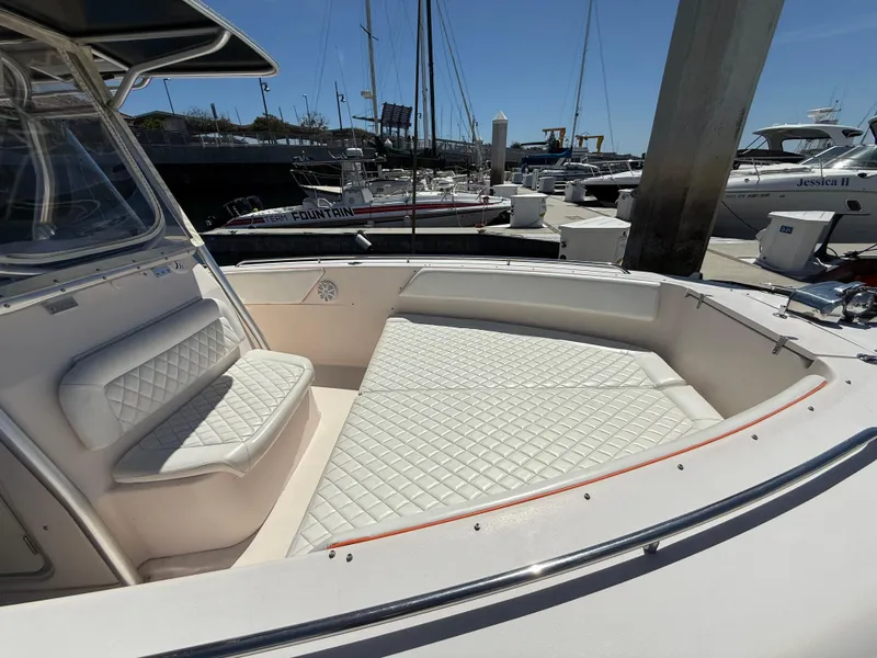 2005 Grady-White Bimini 306 boat with white cushioned seating at a marina.