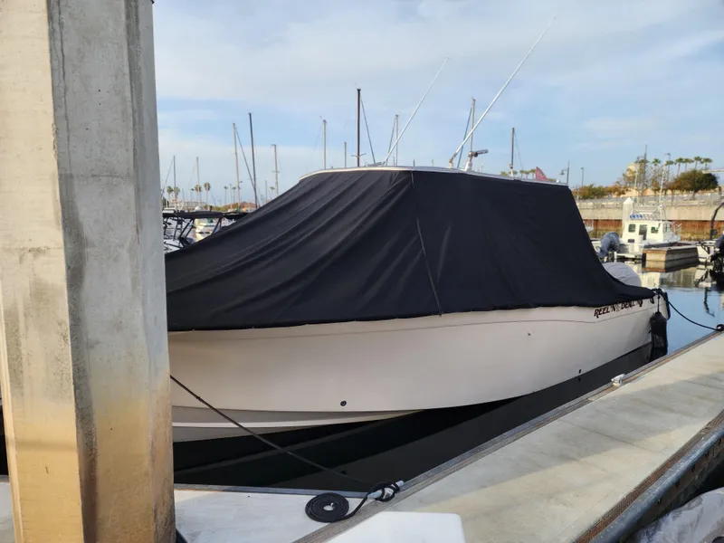 2005 Grady-White Bimini 306 boat covered at marina dock.