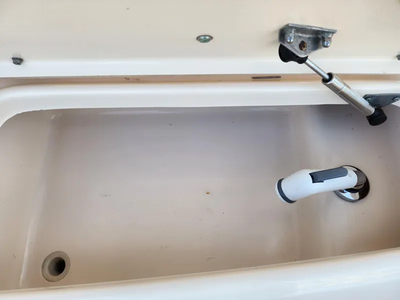 Livewell compartment of 2005 Grady-White Bimini 306 boat, featuring drainage and hydraulic support.