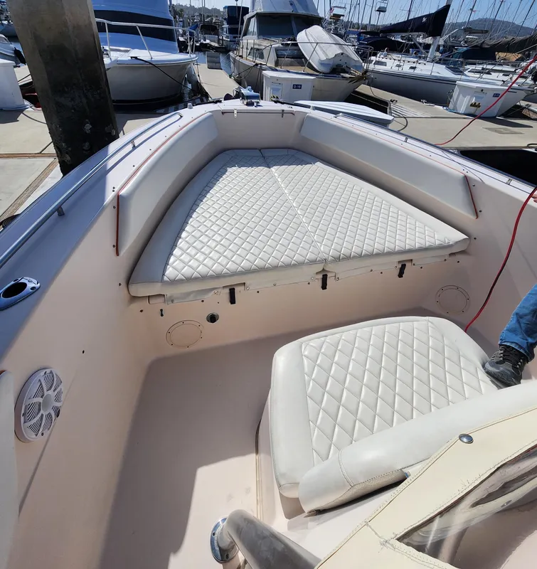 2005 Grady-White Bimini 306 boat interior with cushioned seating at a marina.
