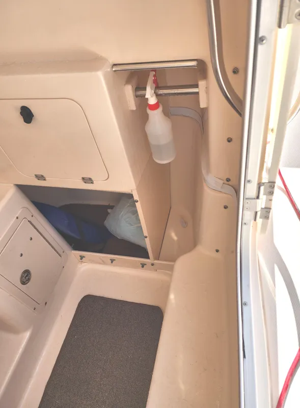 2005 Grady-White Bimini 306 interior with storage compartments and cleaning supplies.
