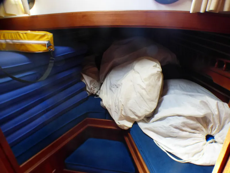 V-Berth Double Bed being used to store Cockpit Cushions, and Sails