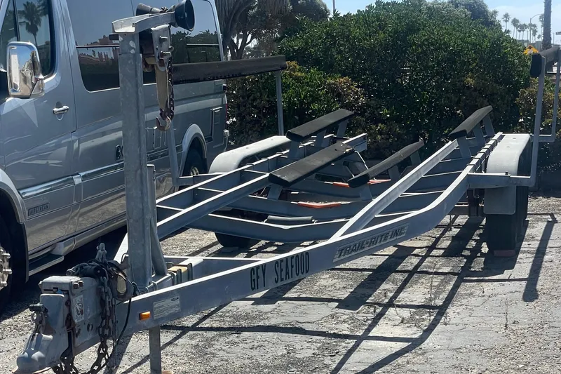 Boat trailer for 2008 Boston Whaler 285 Conquest, parked beside a silver van.