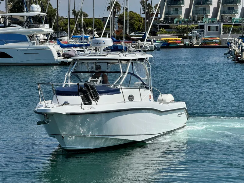 2008 Boston Whaler 285 Conquest boat cruising in a marina with other vessels.
