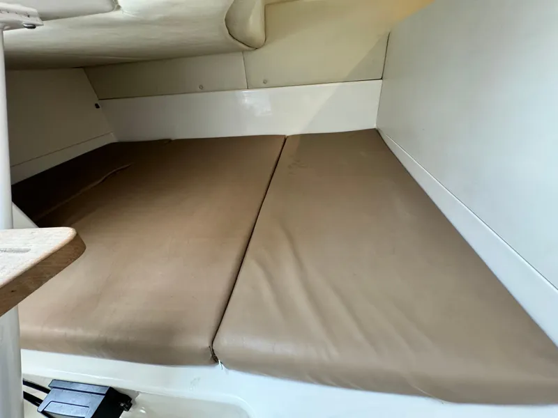 2008 Boston Whaler 285 Conquest cabin interior with beige cushions.