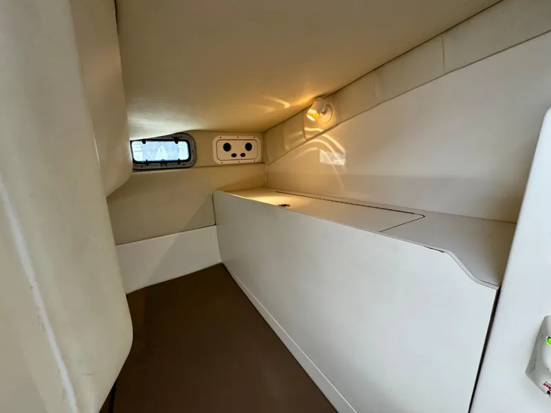 2008 Boston Whaler 285 Conquest cabin interior with compact, minimalist design and small window.