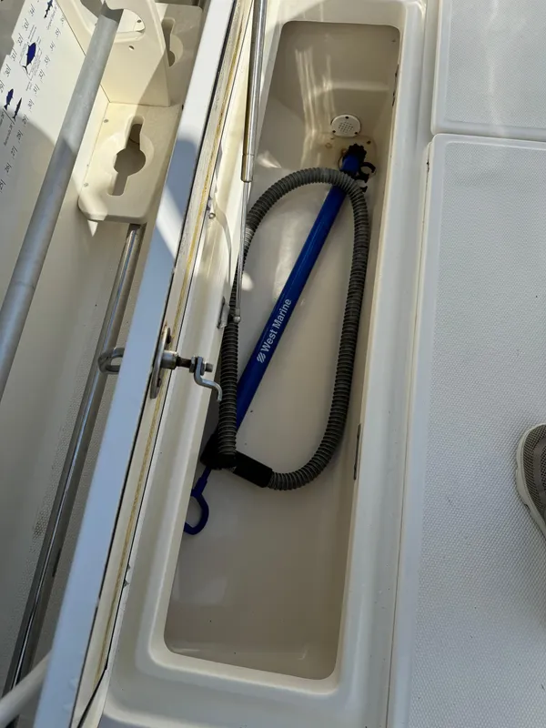 2008 Boston Whaler 285 Conquest storage compartment with hose and equipment.