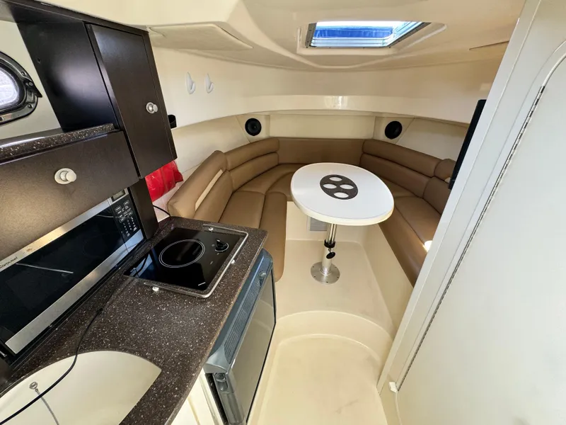 2008 Boston Whaler 285 Conquest cabin interior with kitchenette and seating area.