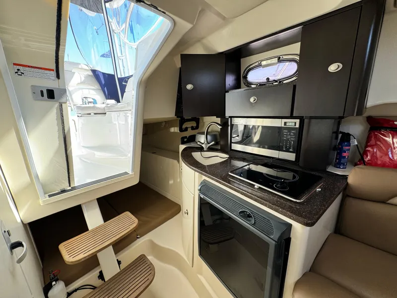 Interior of 2008 Boston Whaler 285 Conquest boat with kitchenette and seating area.