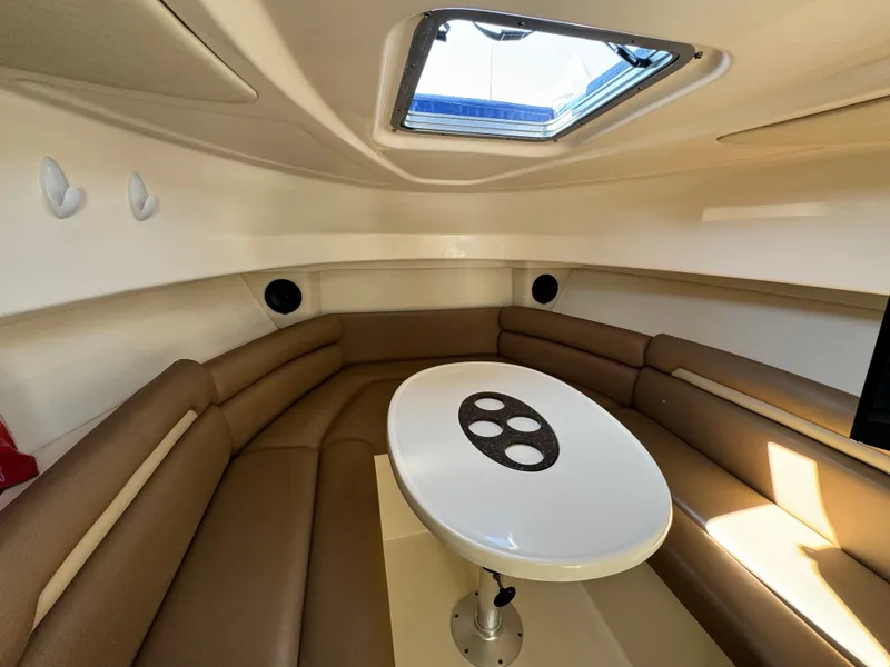 2008 Boston Whaler 285 Conquest cabin interior with brown seating and round table.