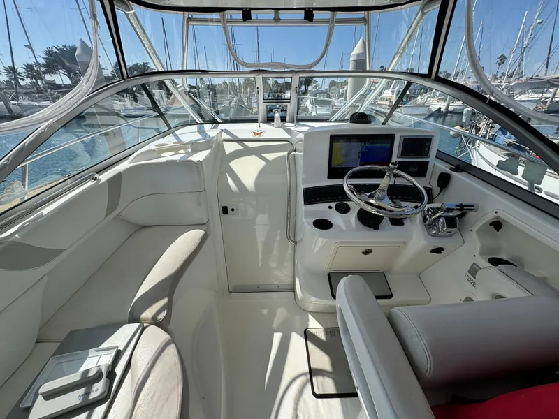 2008 Boston Whaler 285 Conquest cockpit with steering wheel, navigation screens, and seating.