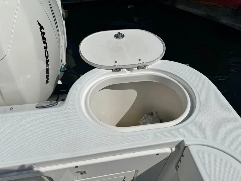 Open storage compartment on 2008 Boston Whaler 285 Conquest boat, near Mercury engine.