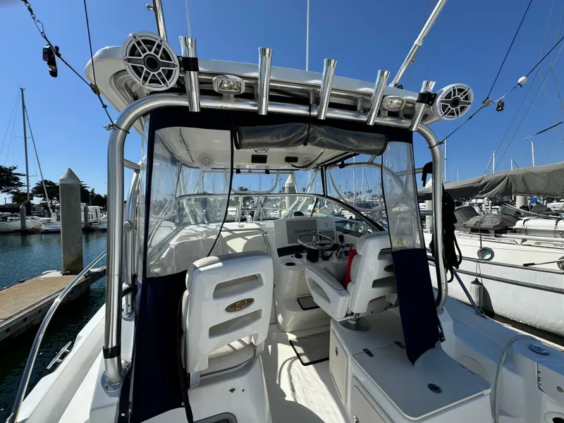2008 Boston Whaler 285 Conquest boat interior with seating and helm, docked at marina.