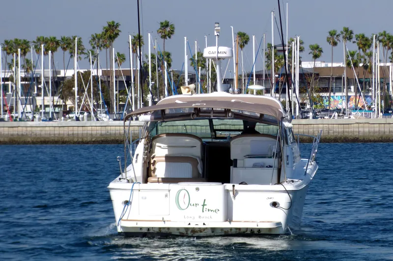 2002 Sea Ray 340 Amberjack boat cruising near marina with palm trees in background.