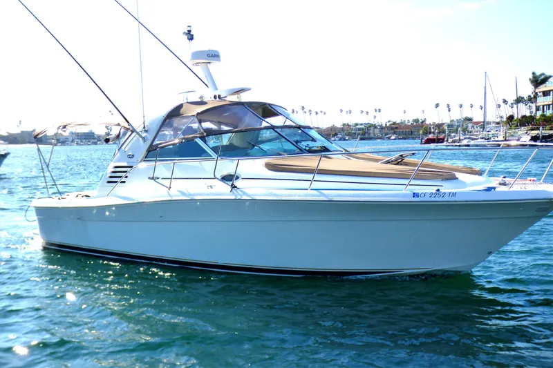 2002 Sea Ray 340 Amberjack boat on water, sunny day, marina background.