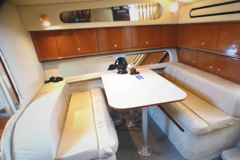 Interior of 2002 Sea Ray 340 Amberjack with cozy seating and dining table.