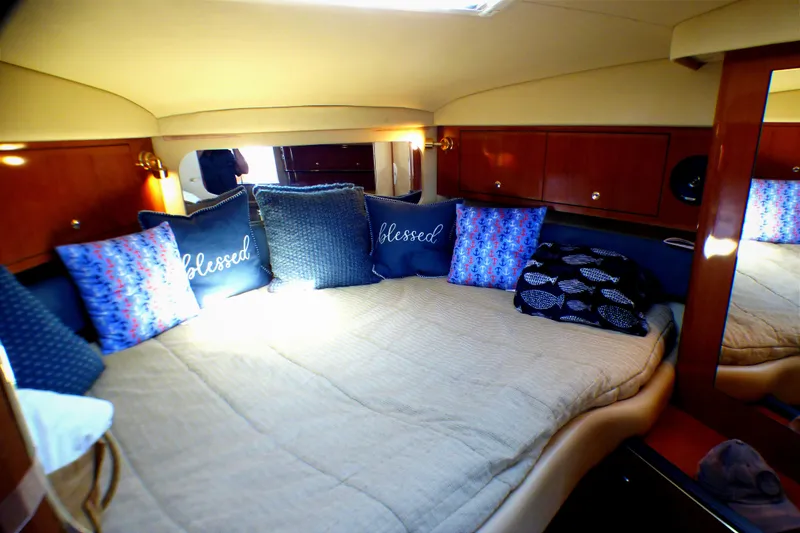Cozy cabin interior of 2002 Sea Ray 340 Amberjack with decorative pillows.