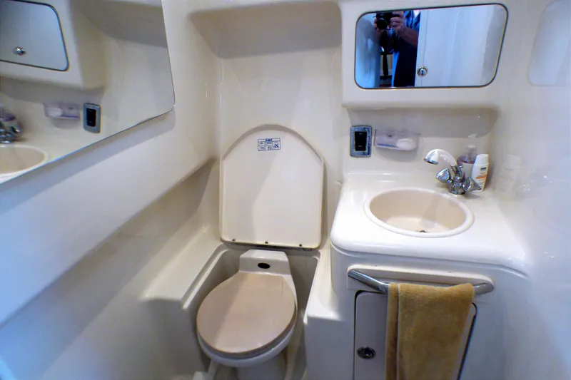 2002 Sea Ray 340 Amberjack bathroom with toilet, sink, and mirror.
