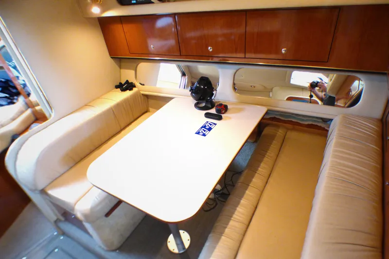 Interior of 2002 Sea Ray 340 Amberjack with cozy seating and wooden cabinetry.